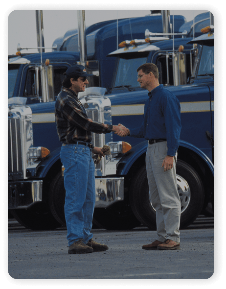 Two men shaking hands in front of a truck